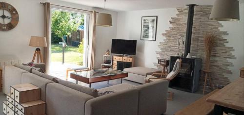 un salon avec un canapé et une cheminée dans l'établissement Location Maison Belle Ile en Mer 10 personnes, au Palais