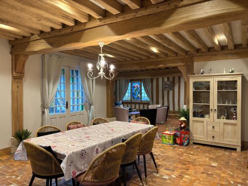 une salle à manger avec une table et des chaises dans l'établissement Chant des mouettes Maison rénovée spacieuse tout confort grand jardin belle terrasse aménagée parking 8 personnes 4 sdb 5 wc à 10 mn à pied de la mer Port en Bessin tous commerces restaurants proche Omaha Beach, à Port-en-Bessin-Huppain