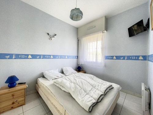 - une chambre avec un lit orné d'écritures bleues sur le mur dans l'établissement Appartement pour 4 pers. avec parking à Stella Plage - FR-1-236-156, à Cucq