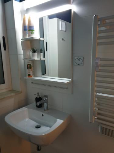 a bathroom with a white sink and a mirror at Nemy Sliema Guesthouse in Sliema