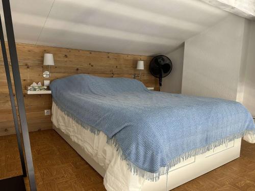 une chambre avec un grand lit avec une couverture bleue dans l'établissement T2 Mezzanine 5 pers - Clim, Parking, Près centre - FR-1-229D-151, à Fleury