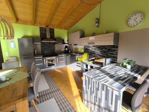a kitchen with a table and a clock on the wall at Ferienhaus Brütting in Pottenstein