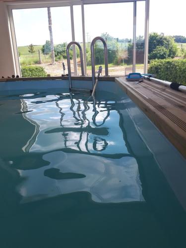 a swimming pool with two chairs in the water at Logement pleine nature in Saint-Bris-le-Vineux