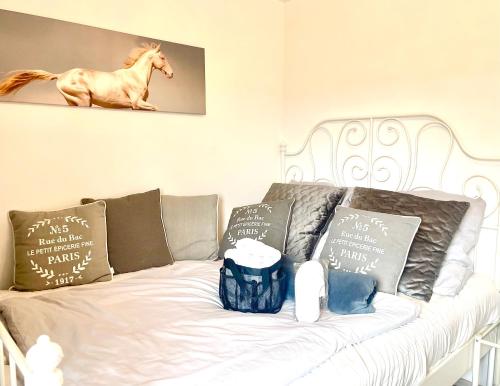 a white couch with pillows and a horse on it at Pferdegut Falkenberg Ferienwohnung in Falkenberg