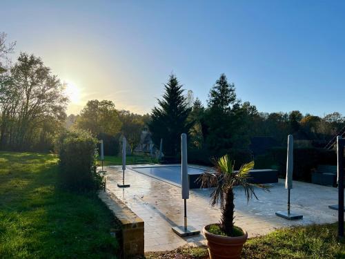 - une piscine avec une plante en pot dans une cour dans l'établissement Gîte - Le Reclaud du Noyer, au Bugue