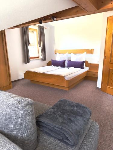 a bedroom with a large bed and a couch at Ferienwohnung Vesna & Alex in Elmen