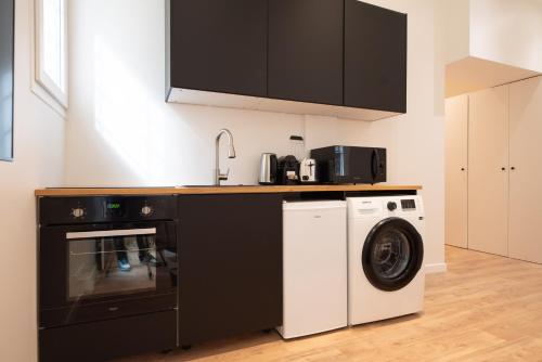 une cuisine avec une machine à laver et un évier dans l'établissement CIA - Luxembourg's Garden Residence, à Paris