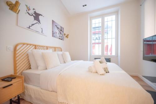 une chambre avec un grand lit blanc et une télévision dans l'établissement CIA - Luxembourg's Garden Residence, à Paris