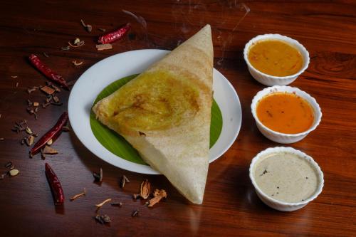 a plate of food with a burrito and dipping sauce at AVANTI CASTELLO in Guruvāyūr