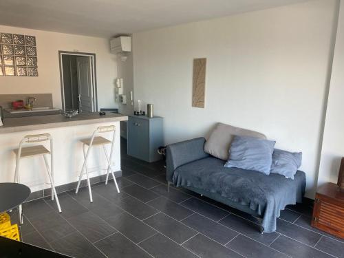 un salon avec un canapé et une cuisine dans l'établissement studio proche de la mer 1 chambre, à Conca