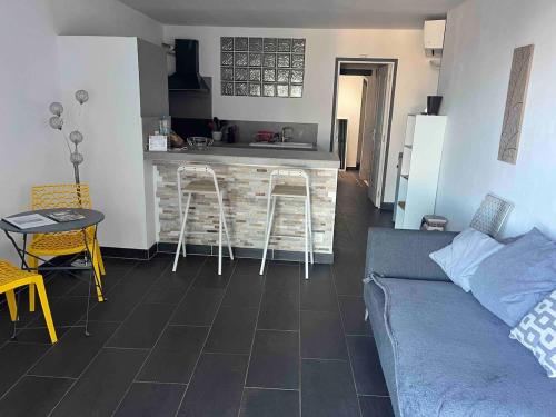 un salon avec un canapé et une cuisine dans l'établissement studio proche de la mer 1 chambre, à Conca