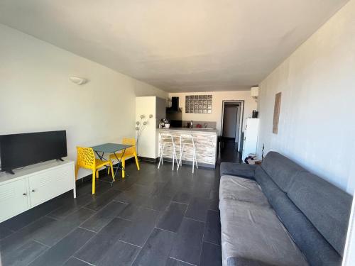 un salon avec un canapé et une table dans l'établissement studio proche de la mer 1 chambre, à Conca
