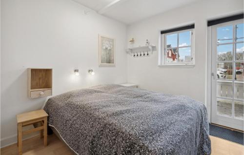 a white bedroom with a bed and two windows at Two-Bedroom Apartment In Grasten in Gråsten