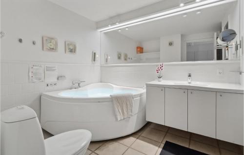 a white bathroom with a tub and a sink at Two-Bedroom Apartment In Grasten in Gråsten