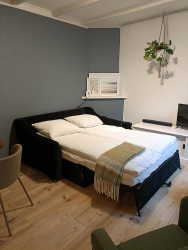 a bedroom with a large bed in a room at Cottage at Sea in Noordwijk aan Zee