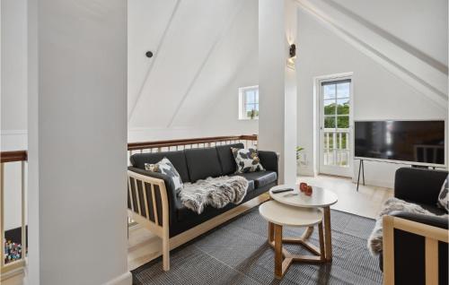 a living room with a couch and a tv at Cozy Apartment In Gråsten With Sauna in Gråsten