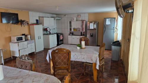 a kitchen with a table with chairs and a refrigerator at Hostal Mirador in San Pedro de Atacama