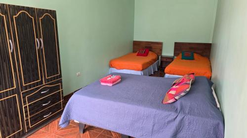 a room with two beds and a dresser in it at Hostal Mirador in San Pedro de Atacama