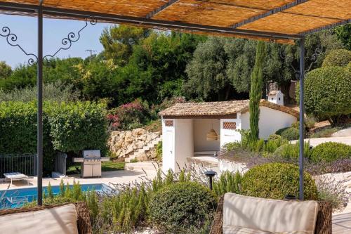 un jardin avec une piscine et une maison dans l'établissement Villa vue panoramique proche Saint-Paul-de-Vence, à Vence