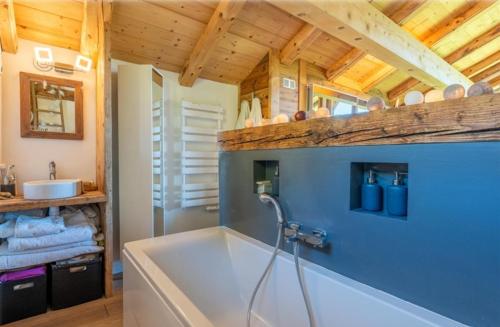 een badkamer met een bad en een wastafel bij Le chalet Leïla in Manigod