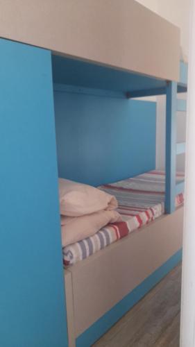 a bunk bed in a room with a blue wall at 2 Bedroom Chalet in Kaslik Generator is including in Jounieh