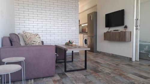 a living room with a couch and a table and a tv at 2 Bedroom Chalet in Kaslik Generator is including in Jounieh