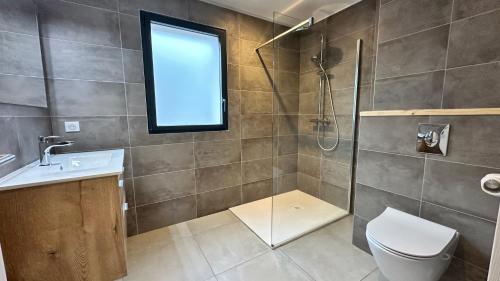 une salle de bain avec douche et toilettes et une fenêtre dans l'établissement Appartement vue mer panoramique & plage à pied Porticcio, à Grosseto-Prugna