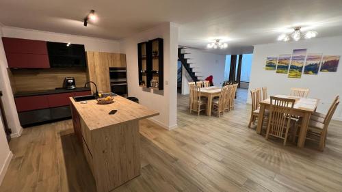 a kitchen and living room with a table and chairs at Domeniul H in Rişca