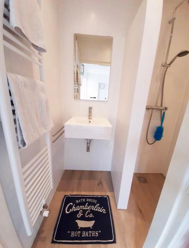 a bathroom with a sink and a sign on the floor at De Strandjuffer Petten in Petten