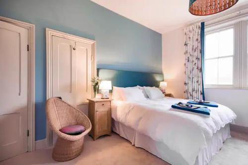 a bedroom with a bed and a chair and a window at Wilde Lodge By Birch Stays in Bucknell