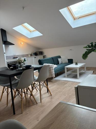 un salon avec un canapé, une table et des chaises dans l'établissement Appart Sofia uckange, à Uckange