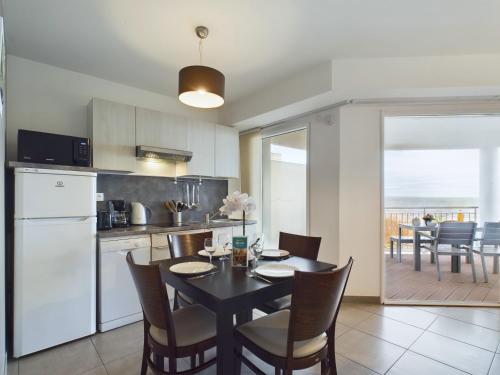 une cuisine et une salle à manger avec une table et des chaises dans l'établissement Vue mer - Appart pour 4 à la Tranche sur Mer, à La Tranche-sur-Mer