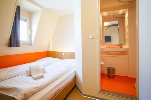 ein kleines Schlafzimmer mit einem Bett und einem Spiegel in der Unterkunft easyHotel Basel City - contactless self check-in in Basel