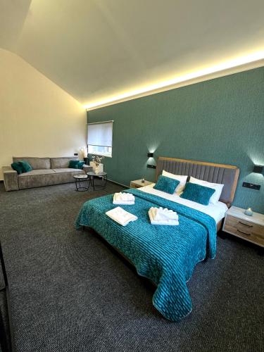 a bedroom with a large bed and a couch at Hotel Nivki in Kyiv