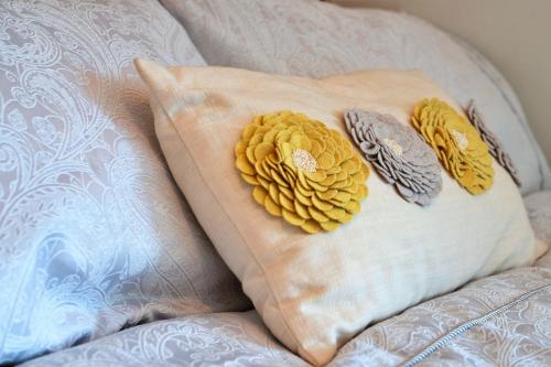 a pillow with yellow flowers on it on a bed at Finest Retreats - Nelly's Nook in Matlock