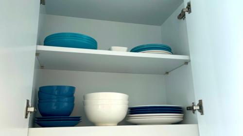 a cabinet filled with blue and white plates and bowls at VIP 375 large studio, ocean view in Rayong