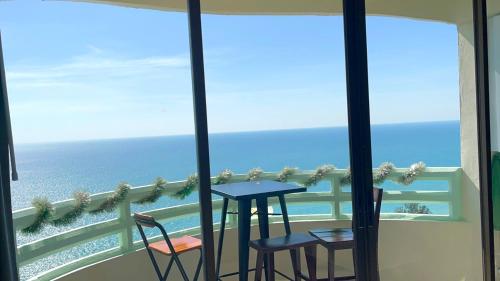 a balcony with a table and chairs and the ocean at VIP 375 large studio, ocean view in Rayong