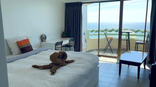 a stuffed teddy bear on a bed in a bedroom at VIP 375 large studio, ocean view in Rayong