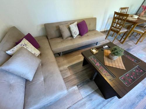 a living room with a couch and a table at Batrouna Park resort Generator is included pool in Batroûn