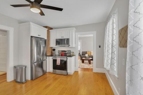 a kitchen with white cabinets and a stainless steel refrigerator at West Hartford Center- Charming New England Apt in West Hartford