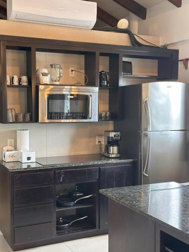 a kitchen with a stainless steel refrigerator and microwave at Maya Beach Hotel in Maya Beach