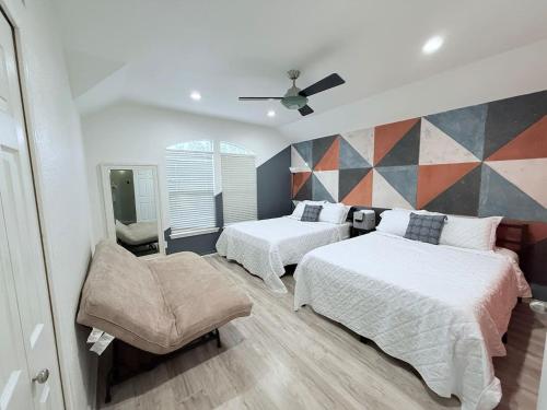 a bedroom with two beds and a chair in it at EaDo Townhome Pool Table By Convention & Stadiums in Houston