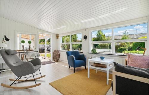 a living room with chairs and a table and windows at Gorgeous Home In Nexø With Wifi in Neksø