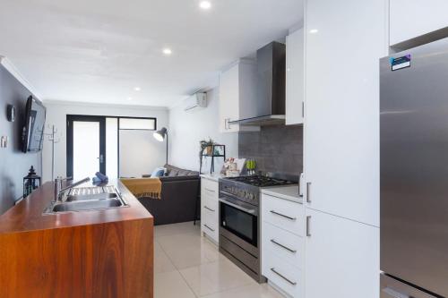 a kitchen with a sink and a stove top oven at The perfect family escape modern huge backyard in Perth