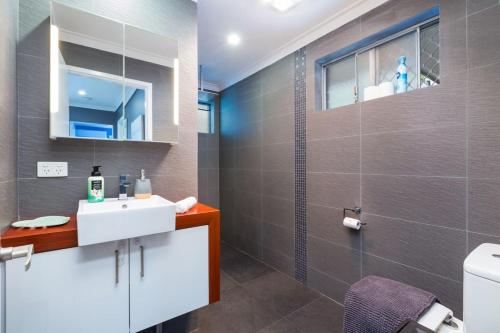 a bathroom with a white sink and a shower at The perfect family escape modern huge backyard in Perth