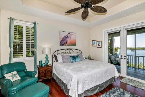 un dormitorio con una cama y una silla en Ozello Manor Waterfront private dock large patio sleeps 8 dog ok, en Ozello