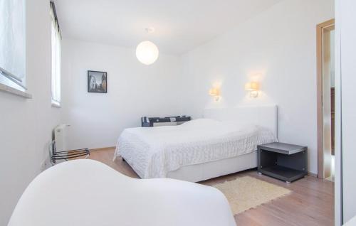 a white bedroom with two beds and a table at Casa Fiori in Fiorini