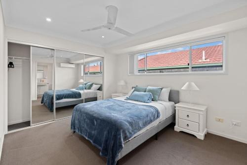 a bedroom with two beds and a mirror at Charming 4Bedroom Home Near Train Station and Beaches in Brisbane