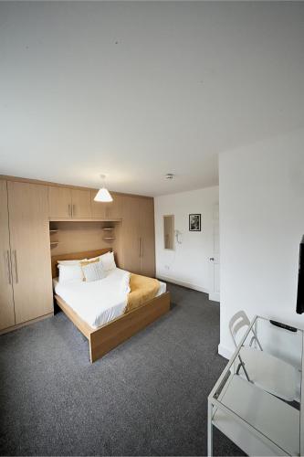 a bedroom with a bed and a chair in it at Private on suites- Private Bathroom every room-1 Bus to Heathrow Airport in Harmondsworth
