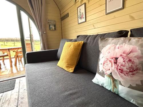 a couch with two pillows and a flower on it at Barnharrow Holiday Pods in Newton Stewart